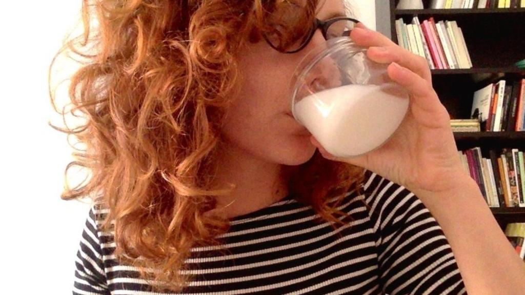 Die Autorin trinkt Muttermilch aus einem Glas – als Erwachsene