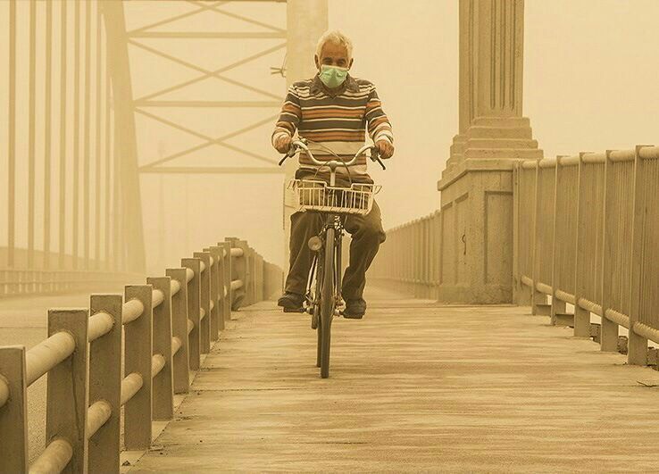 A cyclist crosses a bridge during a dust storm in Ahvaz. Image: Ali Shakiba