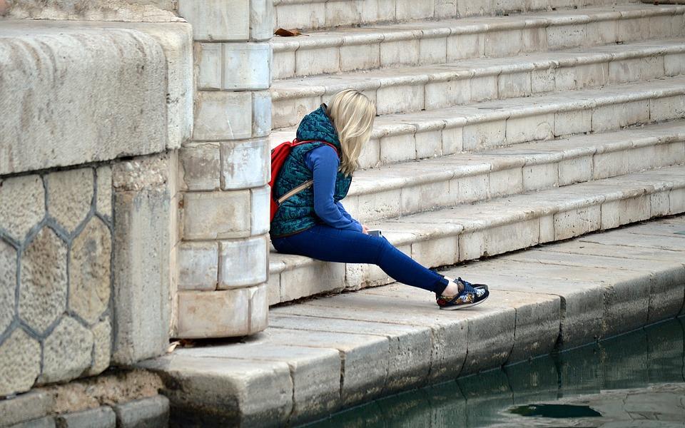 Frau sitzt nach Beziehungsende alleine auf Stufen