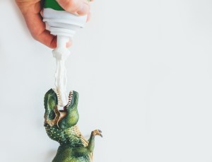 whipped cream sprayed into toy dinosaur's mouth