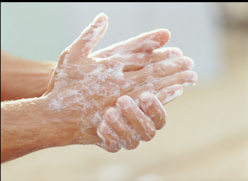 person washing their hands with soap