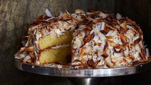 a cake stand holding a toasted coconut layer cake using pantry staples