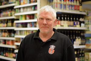 Een supermarktmedewerker voor een schap