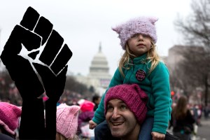 Ein Mädchen mit pinkfarbener Mütze auf den Schultern ihres Vaters, Demo, Women's March