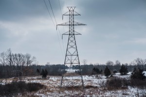 A tower with power lines in the countryside.