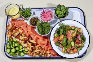 a breakfast platter of bagel chips, lox, cucumbers, dill, red onions, and capers for an everything bagel and nova panzanella