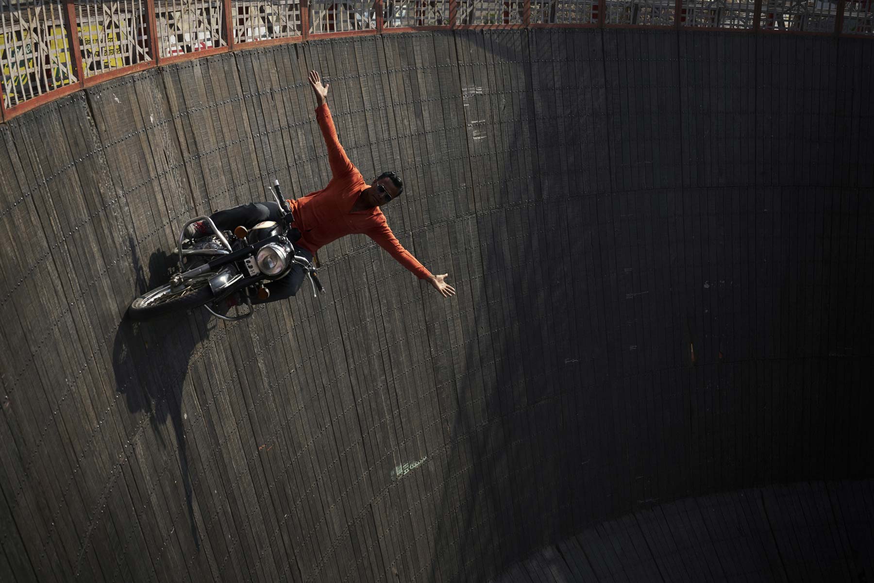 Ein Stunt-Fahrer fährt auf seinem Motorrad die Steilwand entlang