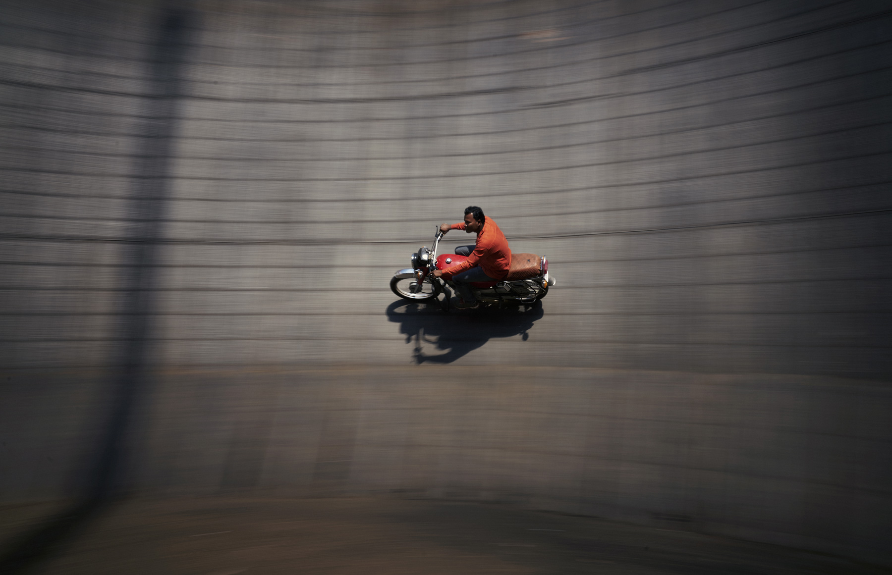 Ein Stunt-Fahrer fährt auf seinem Motorrad die Steilwand entlang