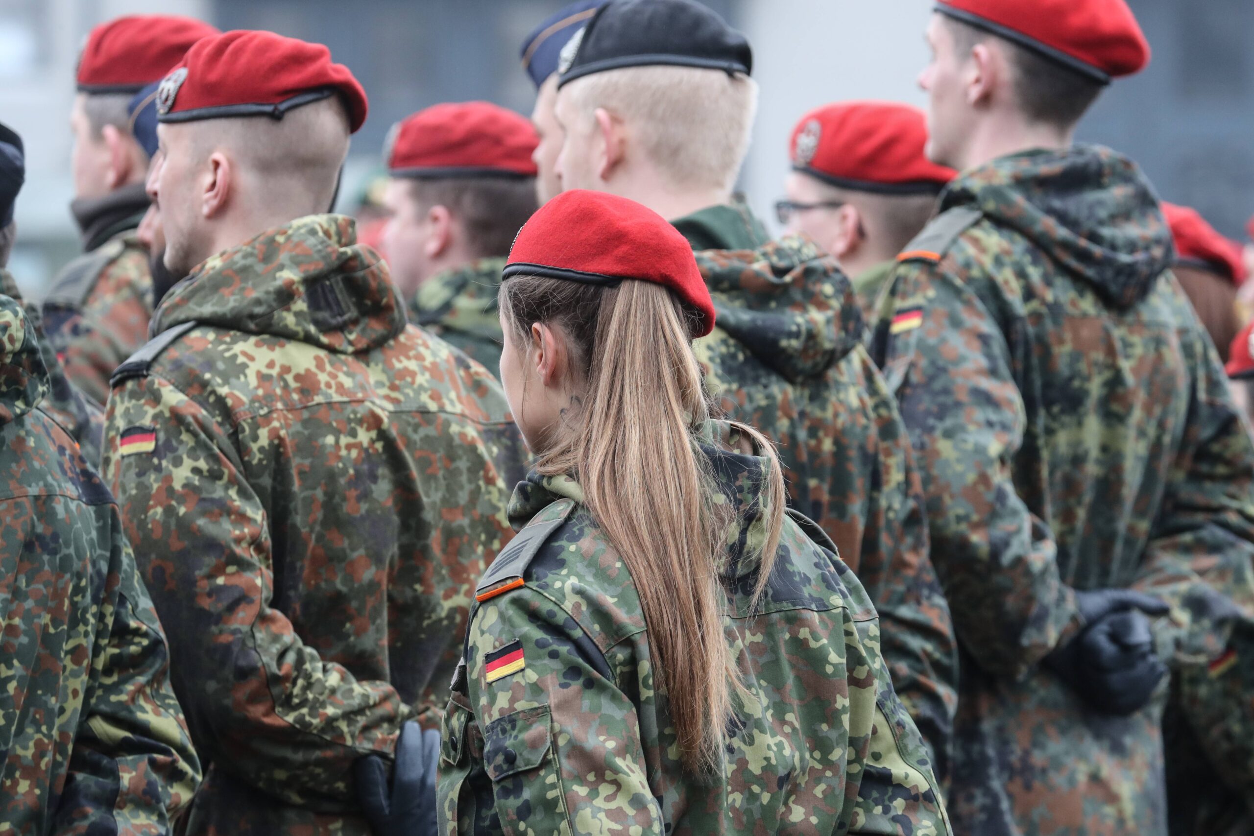 Eine Gruppe von Bundeswehrsoldaten steht mit hinter den Rücken verschränkten Armen in mehren Reihen