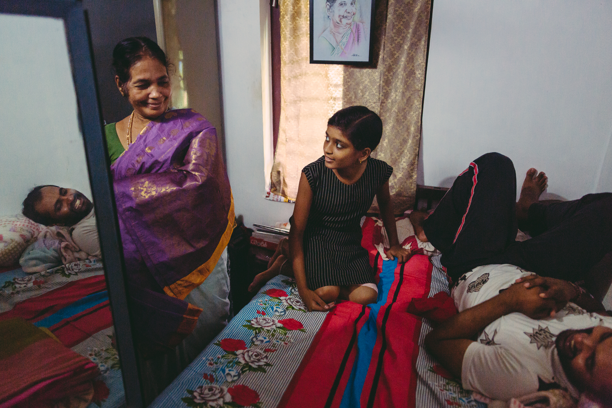 Meenakshi Raghavan zeigt ihren Enkelkindern Lena und Jithin ihre Sari-Sammlung.