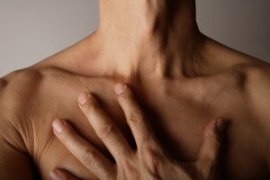 topless man with hand on chest