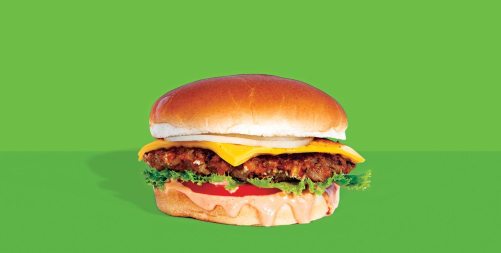 a veggie burger from burgerlords in los angeles in front of a plain green background