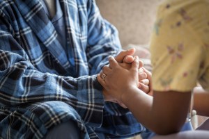 a worker hold the hands of an elderly person