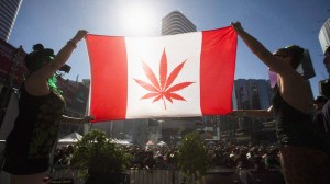 Two people hold a modified design of the Canadian flag with a marijuana leaf in in place of the maple leaf during the 420 Toronto