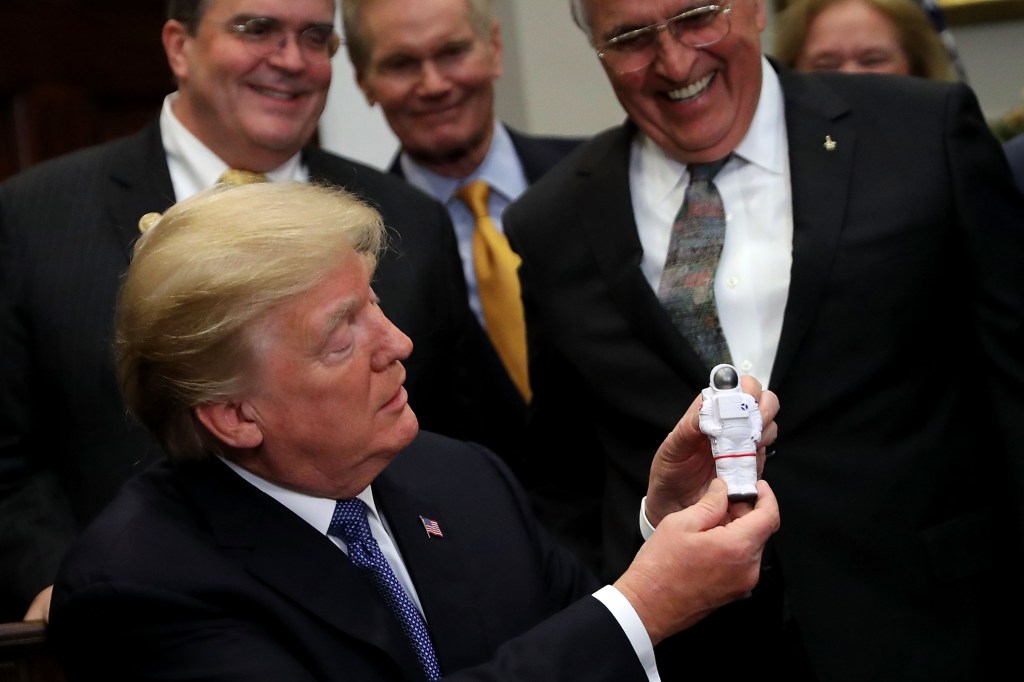 Trump plays with an astronaut toy.