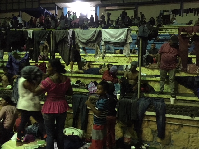 Central American migrants gather in a gym turned shelter.