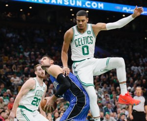 Jayson Tatum leaves his feet to try and block Nikola Vucevic's shot.