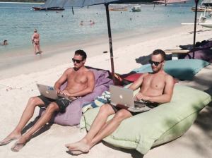 Steffen og en ven ligger på en strand med en bærbar computer