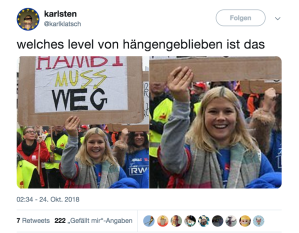 Eine Frau mit einem Schild, auf dem "Hambi muss weg" steht