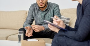 A young man sitting on a couch having a conversation with his therapist