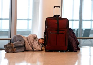 A man naps on the floor of an airport