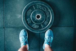 Man standing in front of a weight plate on the ground