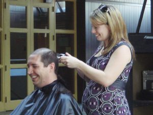 mujer cortándole el pelo aun hombre