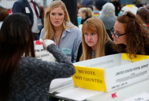 People look at an elections worker during a ballot recount.