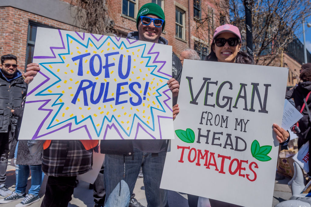 Two Vegan demonstrators holding signs