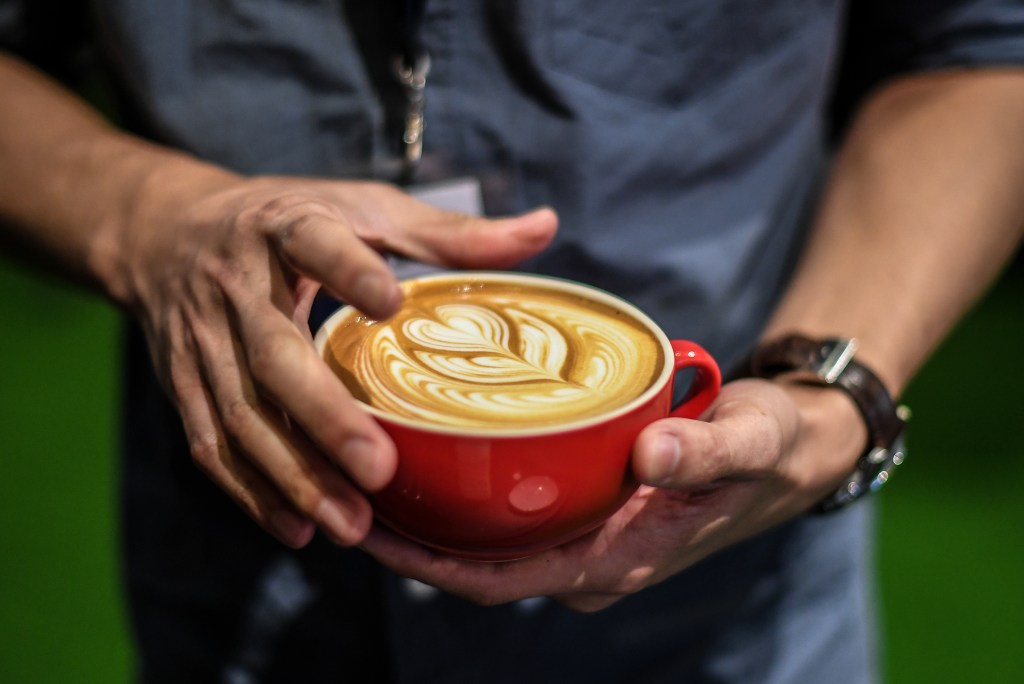 Man's hands holding latte