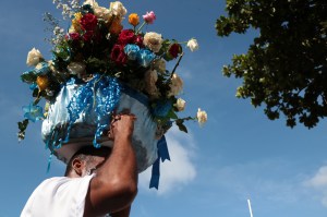 Homem carrega flores na cabeça