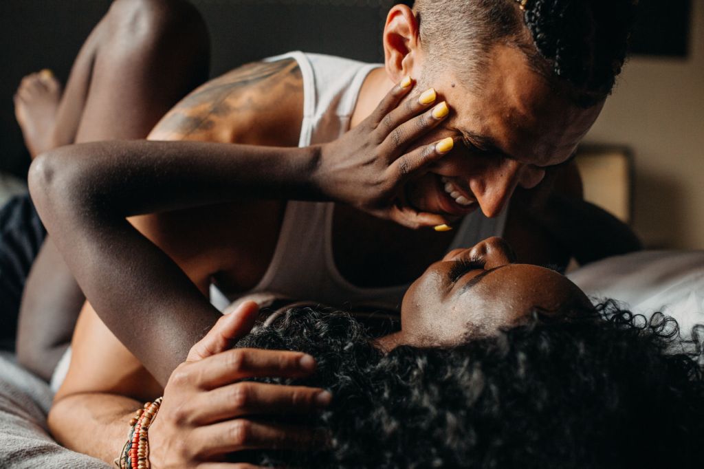 Woman and man smiling in bed