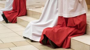 Drei Geistliche knien vor einem Altar