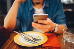 person holding phone while dining​