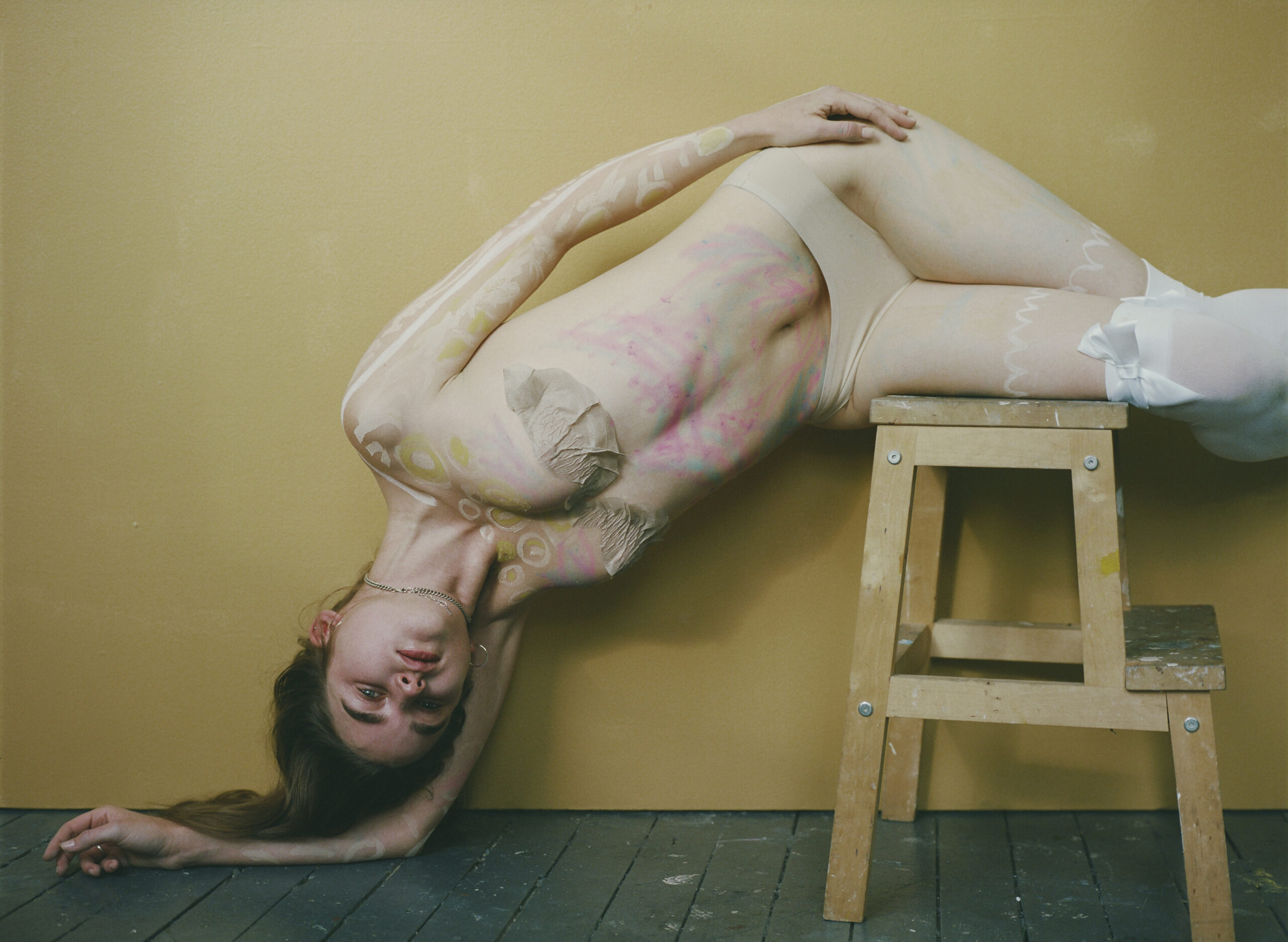 a girl lying on top of a stool