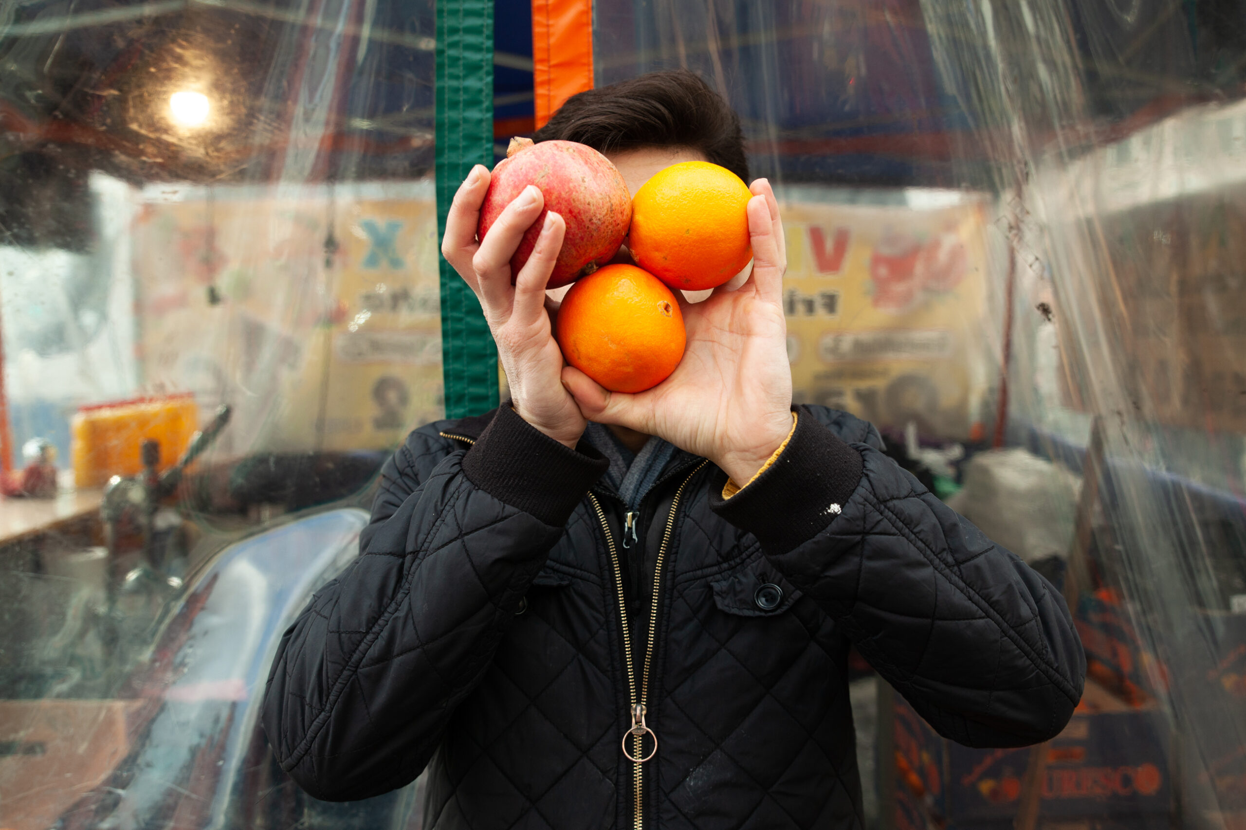 Man hält sich Obst vor das Gesicht