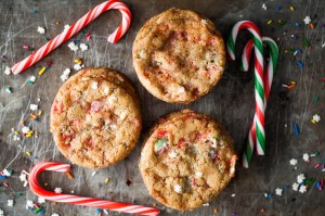 holiday sugar cookies with christmas-themed sprinkles next to candy canes