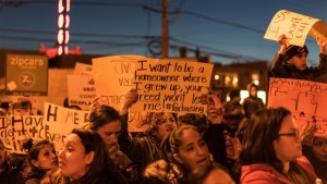 Menschenmenge mit Protestschildern in Chicago bei Demonstration gegen Gentrifizierung