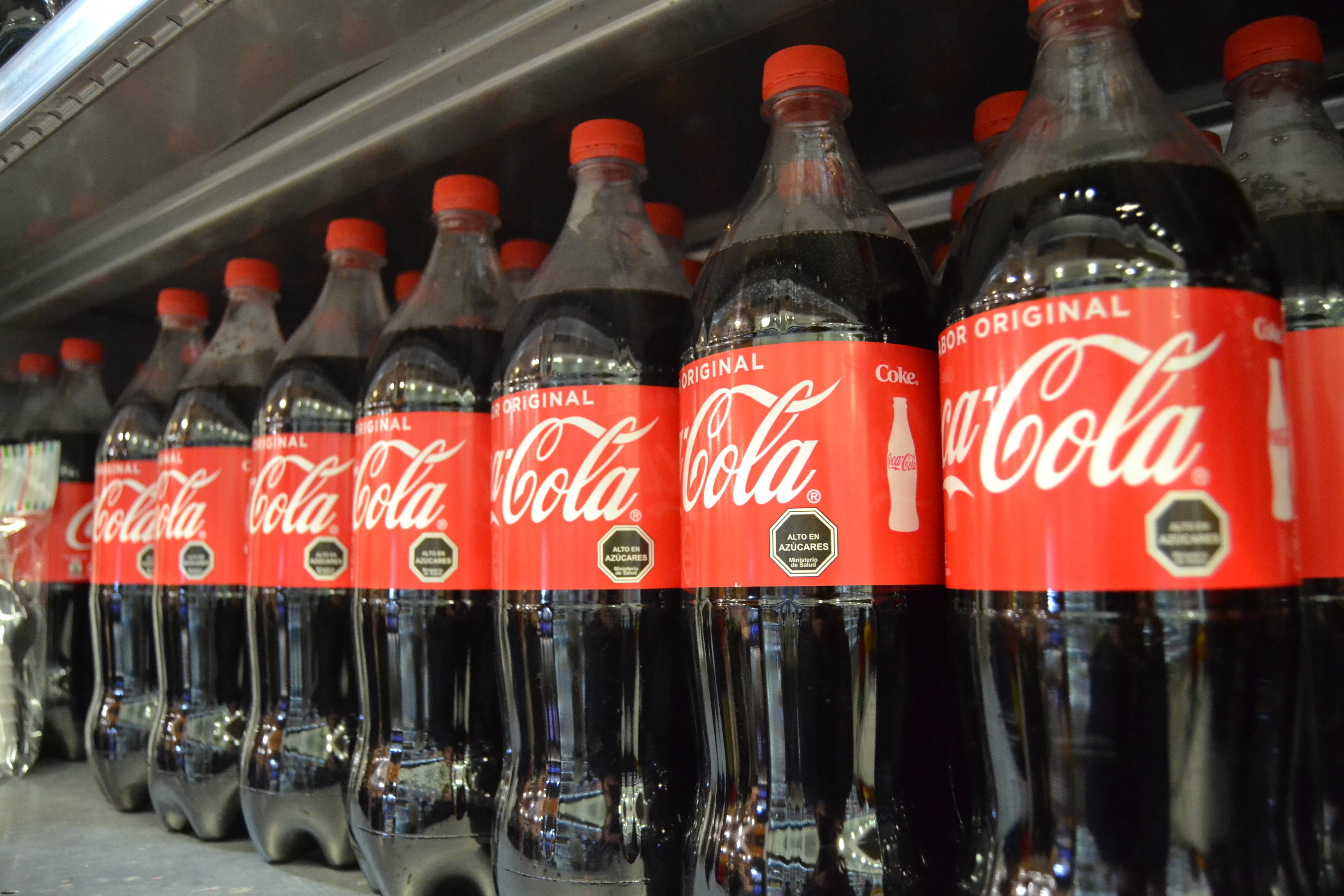 Coca Cola bottles with black labels indicating high sugar content.