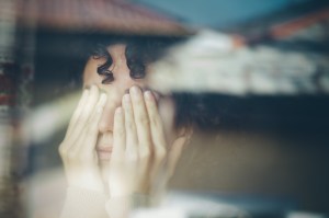 Vrouw met handen voor haar ogen van ellende