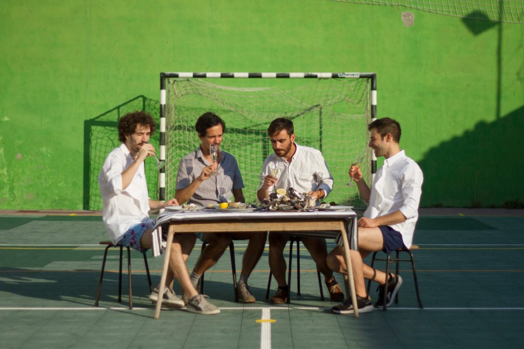 A banda MELQUIADES SENTADA A UMA MESA NUM CAPO DE FUTEBOL DE CINCO