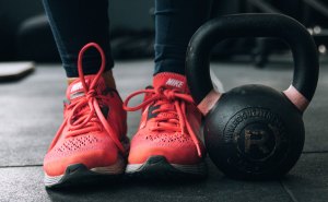 Zapatillas de mujer junto a una pesa.