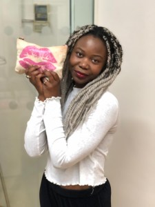 Natasha Mwansa holding up her makeup bag