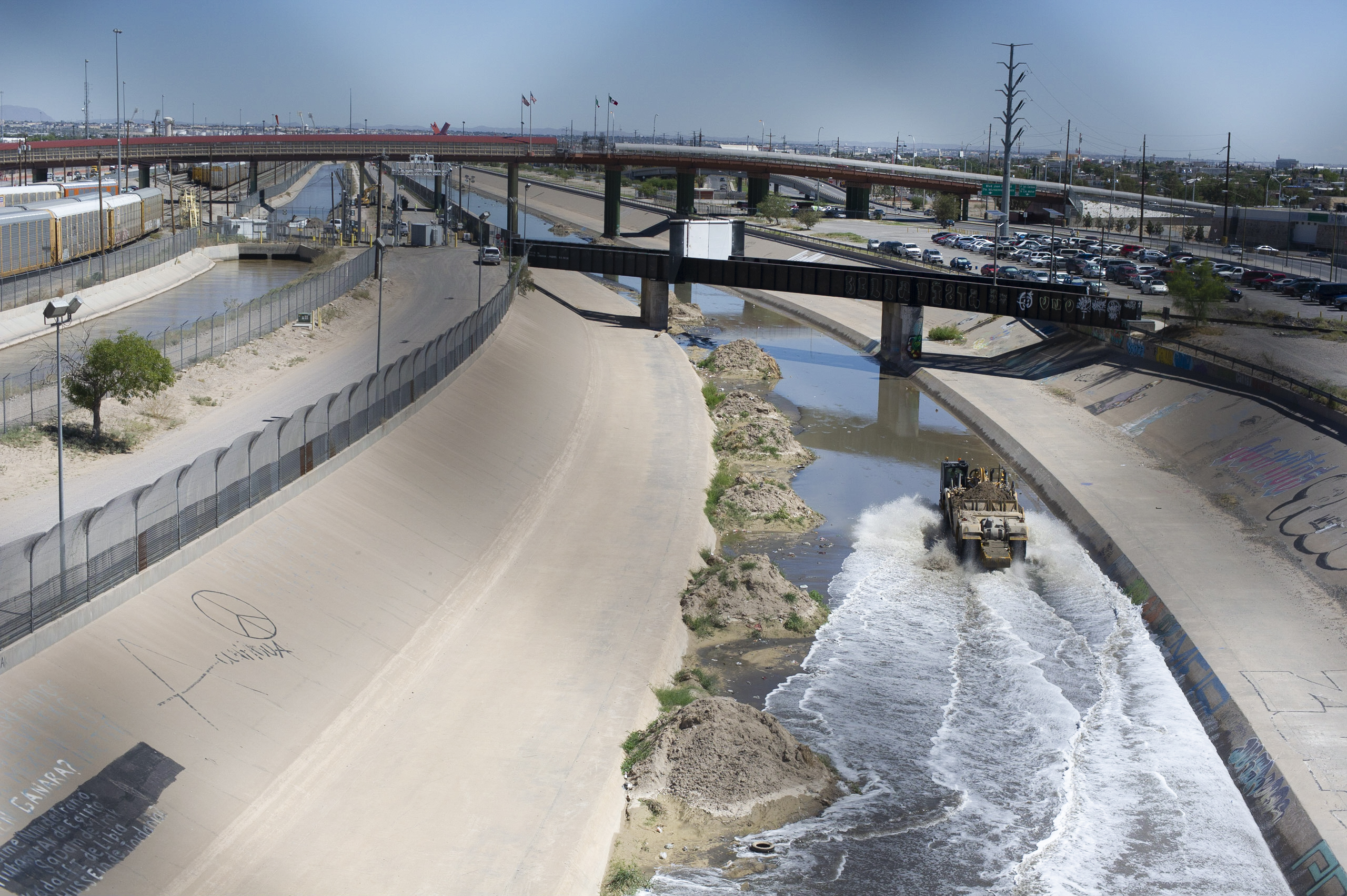 A maintenance vehicle drives down the Rio Grande canal.