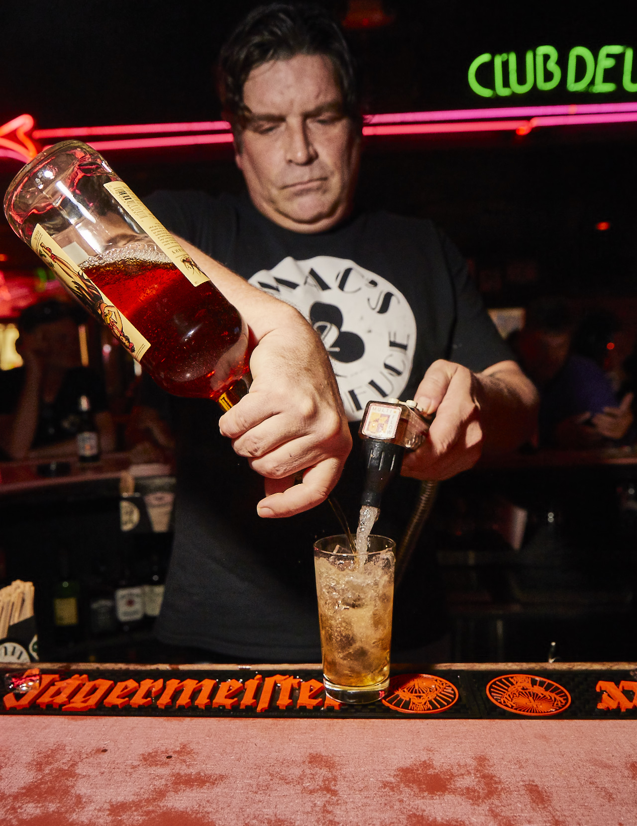 Bartender pouring a drink at Mac's Club Deuce