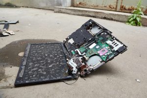 Zerstörter Laptop liegt auf der Straße