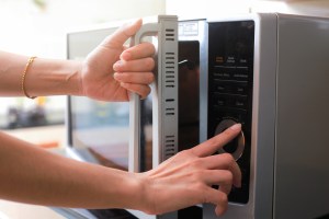 Mujer usando horno de microondas