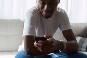 Man sitting on couch holding a phone