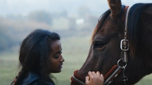 Amy står sammen med en hest udenfor.