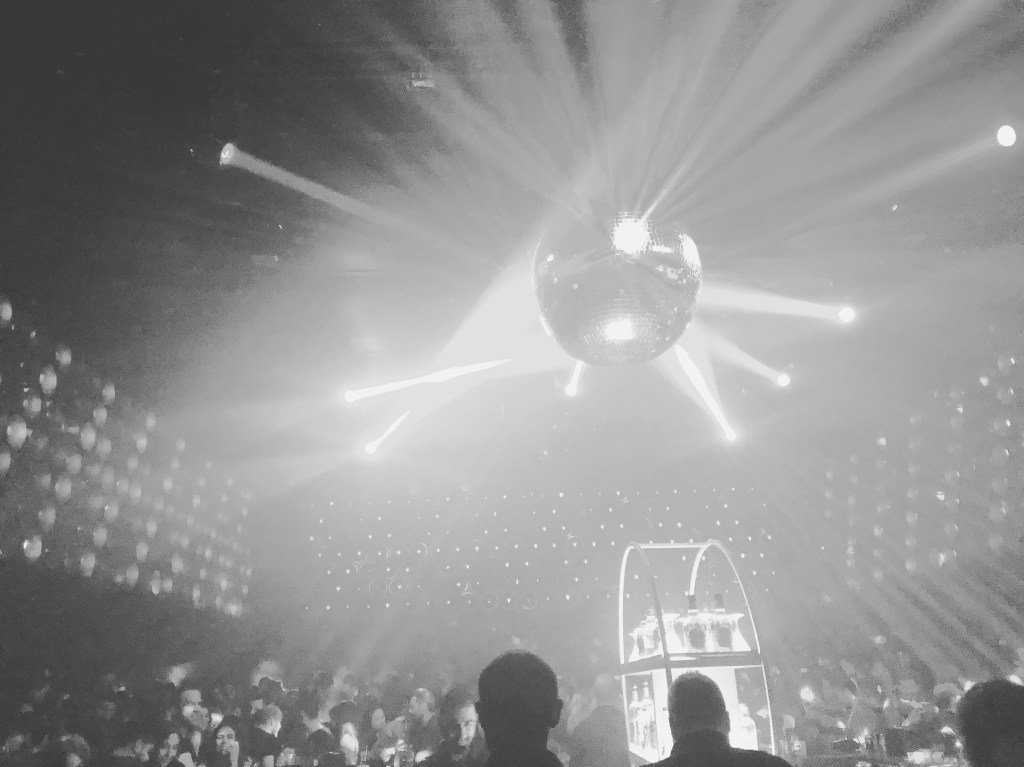 black and white photo of a disco ball in a club